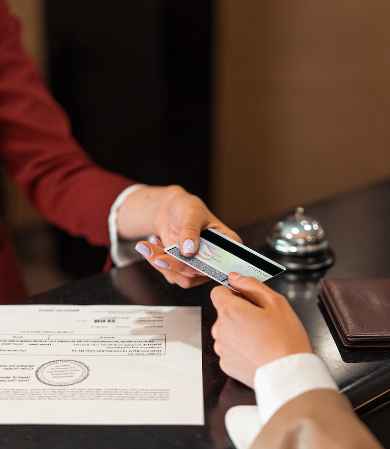 Guest handing their ID across the counter at a hotel front desk