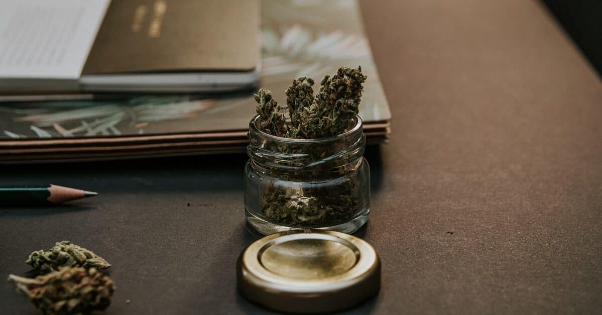 marijuana buds on desk with notebook