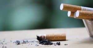 partially burned cigarette with others in the ash tray